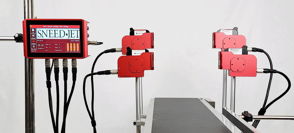 Rear view of SNEED-JET Titan 44 multi-head thermal inkjet printer showing four aligned print heads positioned over a conveyor surface