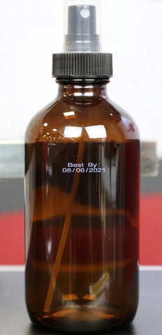 Amber glass spray bottle with white best-by date printed directly on the bottle using a SNEED-JET Titan thermal inkjet printer