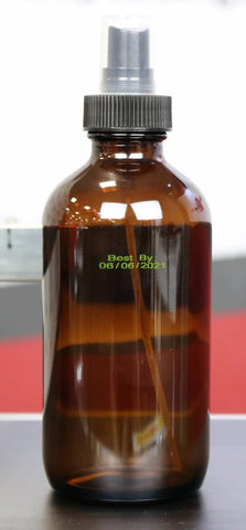 Amber glass spray bottle with yellow best-by date coding printed directly on the bottle with a SNEED-JET Titan printer